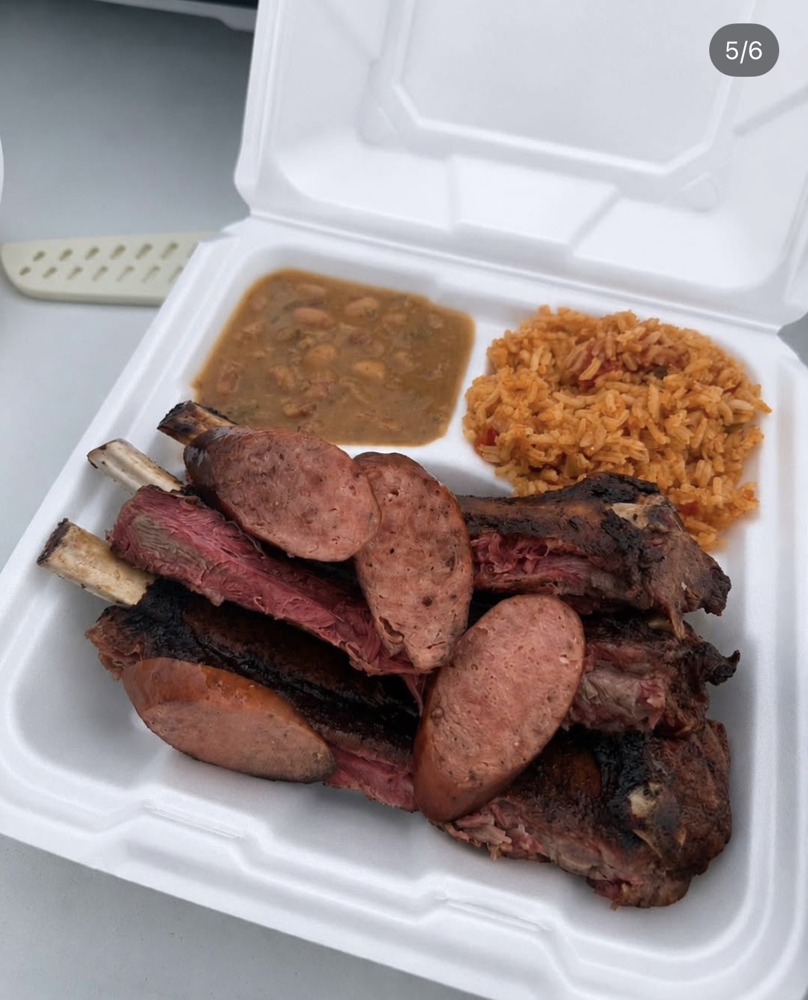 Smoked bison ribs plate with sausage, rice and beans